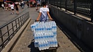 A man delivers plastic bottles of water during a hot day in Istanbul, Turkey, Saturday, June 20, 2026. (AP Photo/Francisco Seco)