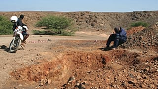 Women sand miners toil stripped Cape Verde beach