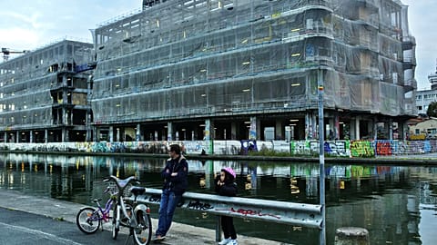 People stand along the canal de l'Ourcq in Pantin, east of Paris, Wednesday, Nov. 12, 2014. 