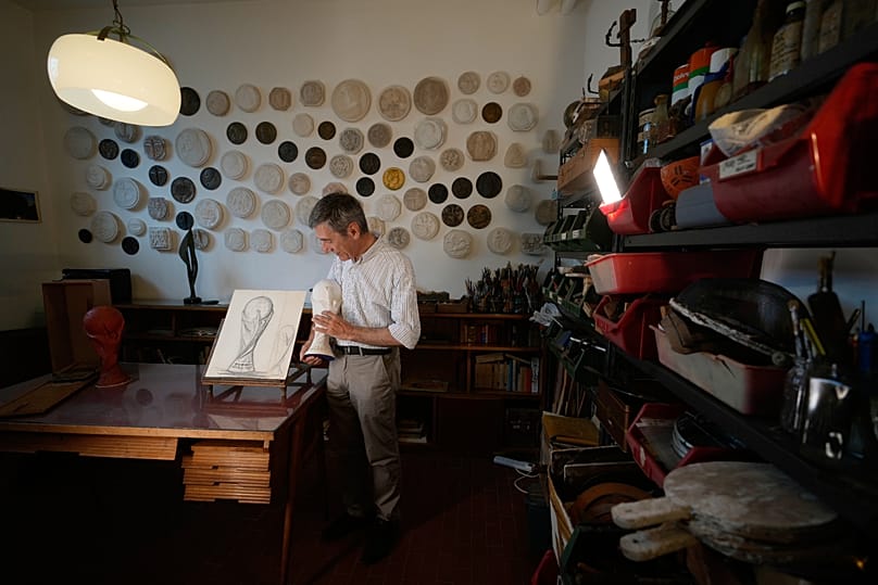 Giorgio Gazzaniga, figlio del defunto scultore Silvio Gazzaniga, tiene in mano una replica del trofeo originale
