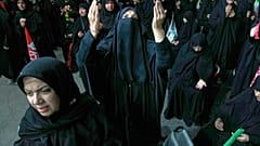 Una donna prega durante una manifestazione a sostegno del governo in una piazza di Teheran, venerdì 17 luglio 2026
