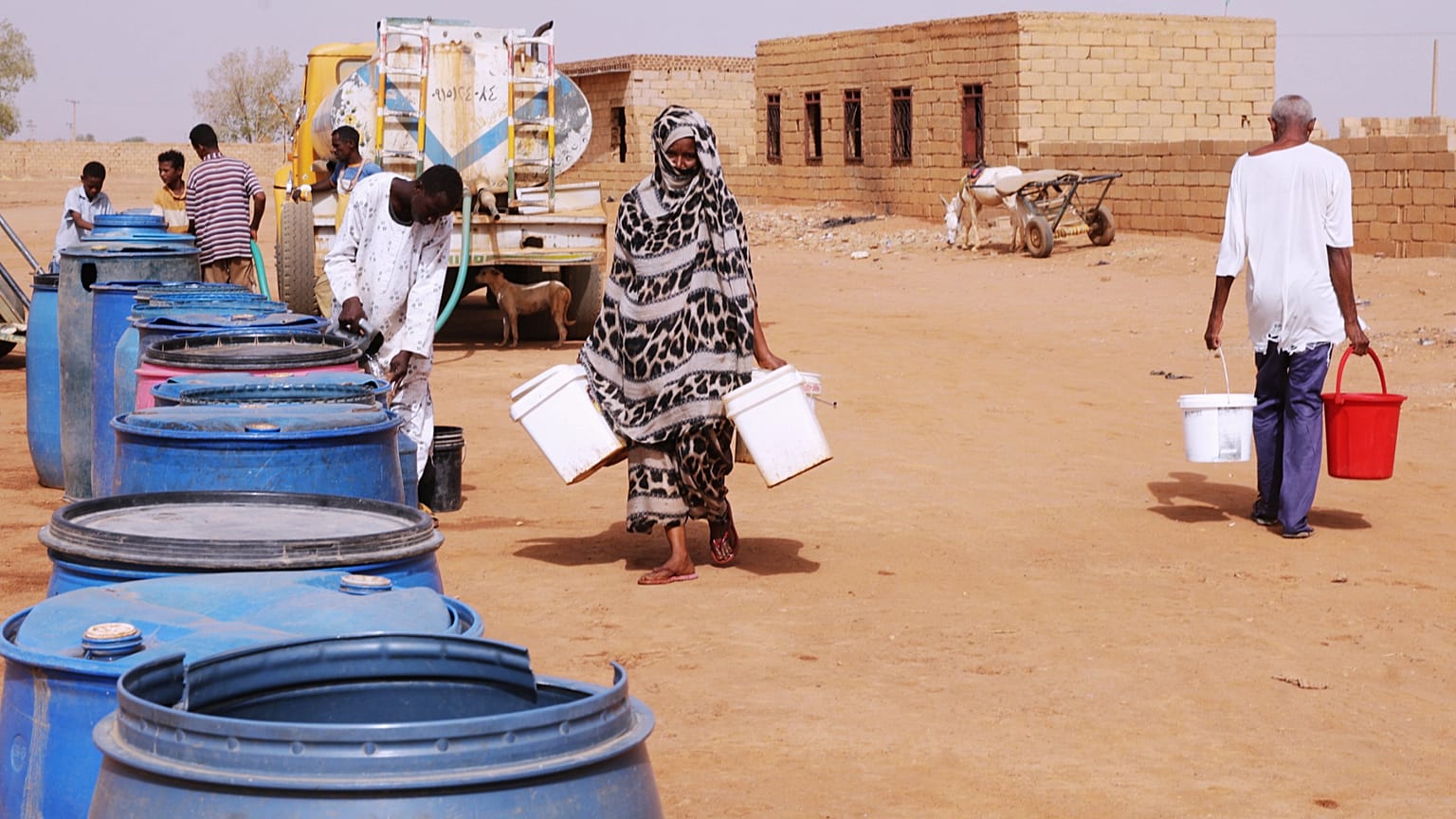 أشخاص يملؤون حاويات المياه في نقطة توزيع مجانية وسط انقطاع المياه في الخرطوم بالسودان، الاثنين 18 مايو 2026. (AP Photo/مروان علي)