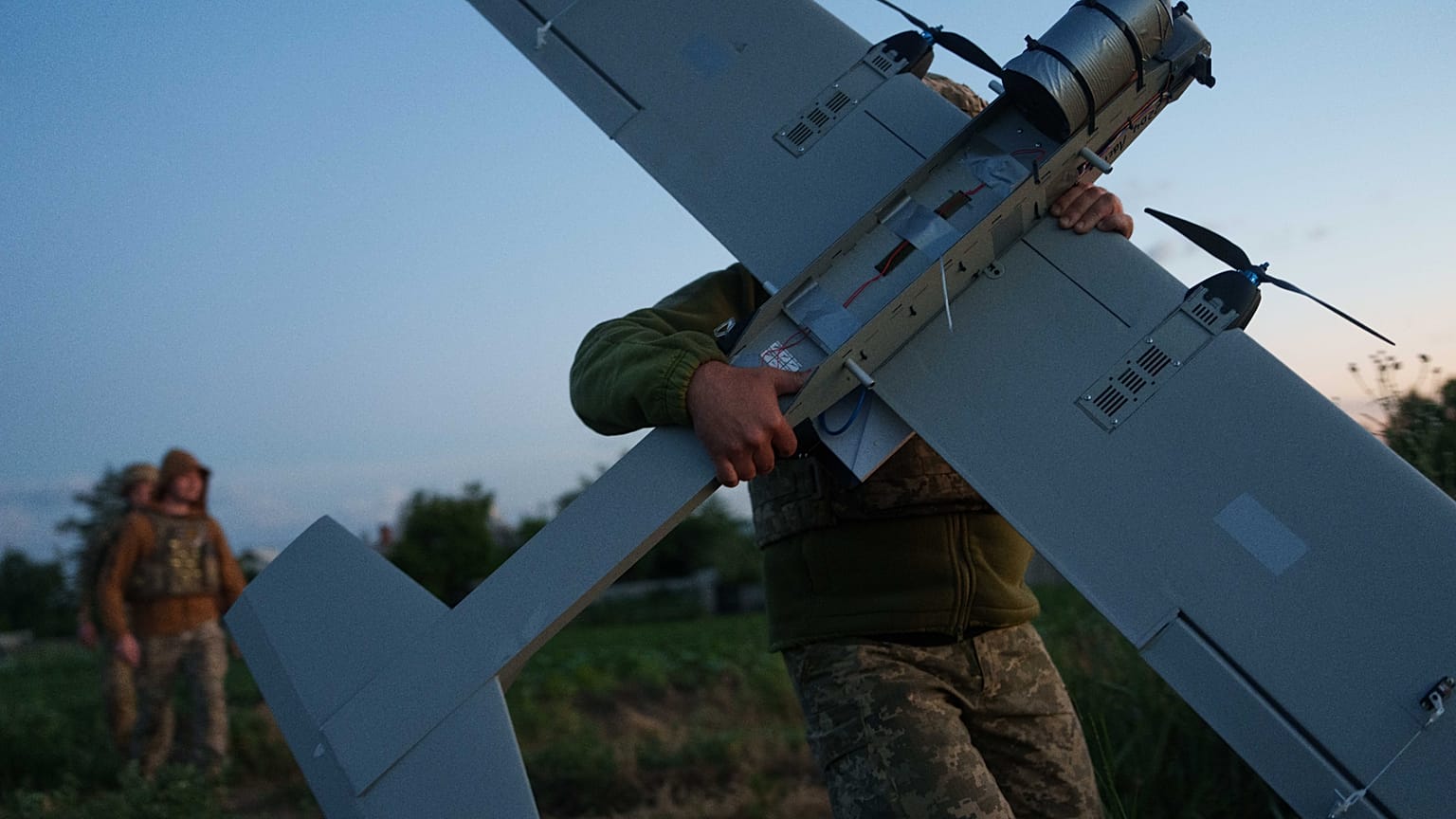 جندي أوكراني من لواء K-2 التابع لقوات الأنظمة غير المأهولة يحمل طائرة بدون طيار متوسطة المدى في موقع الإقلاع قبل أن يطير نحو المواقع الروسية على خط المواجهة في منطقة دونيتسك