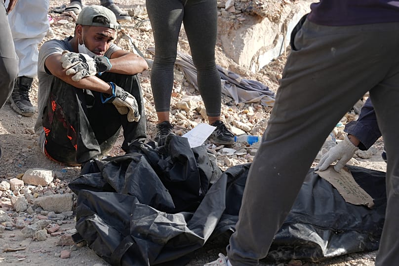 يجلس ليونيل جوتيريز بجوار رفات ابنه ديلان جوتيريز ووالدة الصبي، اللذين استعادهما هو ومتطوعون آخرون من تحت أنقاض منزلهما بعد ثلاثة أسابيع من انهياره خلال الزلازل