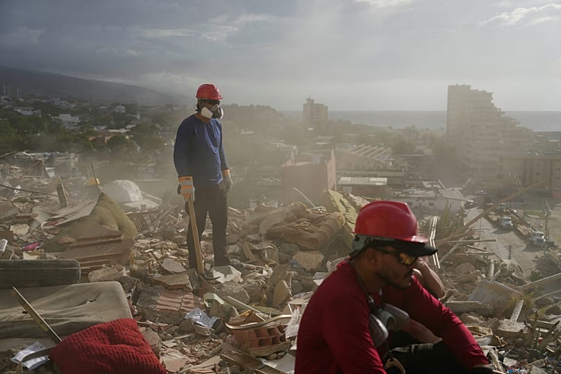 Venezuela’nın La Guaira kentinde, depremler sırasında çöken bir binanın enkazı arasında arama yapan kurtarma görevlileri ve gönüllüler