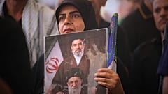 يحمل أحد المعزين صورة تصور المرشد الأعلى الإيراني آية الله مجتبى خامنئي، في الأعلى، ووالده الراحل آية الله علي خامنئي، خلال موكب جنازة خامنئي الأكبر داخل ضريح الإمام علي