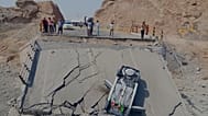 خودروی واژگون شده بر روی بخشی از پل تخریب شده در استان هرمزگان