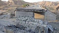 People stand on a bridge destroyed after a strike in Hormozgan province, southern Iran