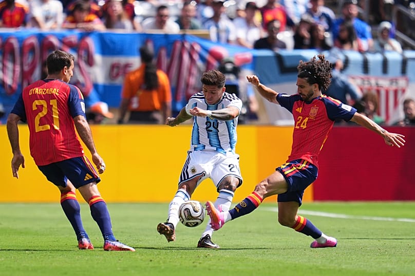 O argentino Enzo Fernandez, ao centro, passa a bola entre Mikel Oyarzabal (21) e Marc Cucurella, ambos de Espanha, à direita, durante a final do Campeonato do Mundo