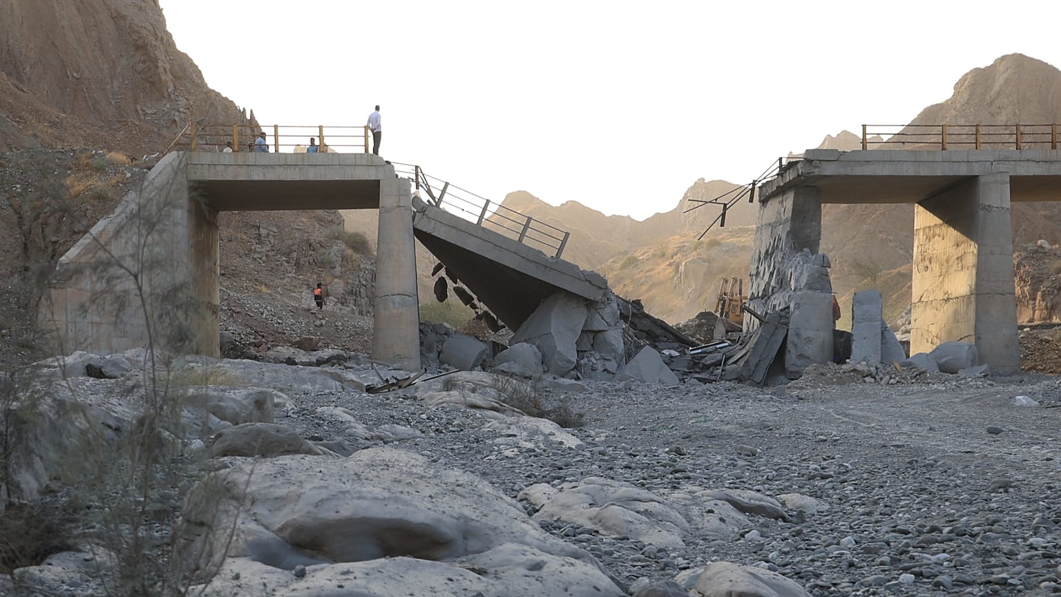 FILE: People stand on a bridge destroyed after a strike in Hormozgan province, southern Iran, 18 July 2026