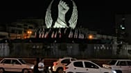 Vehicles drive past a monument depicting the clenched fist of the late Iranian Supreme Leader Ayatollah Ali Khamenei in Islamic Revolution Square in Tehran, July 19, 2026.