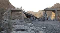 FILE: People stand on a bridge destroyed after a strike in Hormozgan province, southern Iran, 18 July 2026