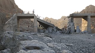 FILE: People stand on a bridge destroyed after a strike in Hormozgan province, southern Iran, 18 July 2026