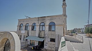 رجل يزيل الأنقاض من أمام مسجد في الضفة الغربية تعرض للتخريب والحرق على يد مستوطنين إسرائيليي، في قرية جلجليا شمال رام الله، الأربعاء 17 يونيو/حزيران 2026