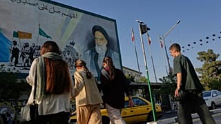 يعبر الناس شارع الثورة الإسلامية تحت لوحة جدارية تصور صورة المؤسس الثوري الإيراني الراحل الخميني في وسط مدينة طهران، إيران، السبت 18 يوليو 2026. 