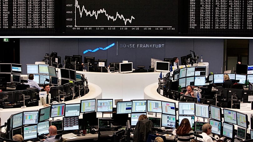 Brokers are seen under the curve of German stock index DAX at the stock market in Frankfurt, central Germany, Monday, Oct. 20, 2008.