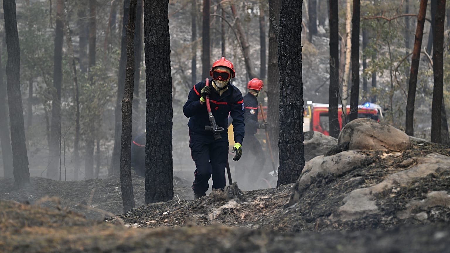 Un pompier transporte une lance à incendie après un feu de forêt dans la région de la forêt de Fontainebleau, au sud de Paris, en France, mardi 14 juillet 2026