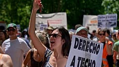Una mujer sostiene una pancarta durante una protesta en Madrid, España, el domingo 24 de mayo de 2026, contra el aumento de los precios de la vivienda.