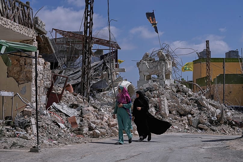 Lübnanlı kadınlar, Lübnan’ın güneyindeki Froun köyünde Hizbullah’la savaş sırasında İsrail saldırılarında yıkılan evlerin yanından geçiyor, 16 Temmuz 2026.