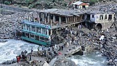 Residents and rescue workers inspect buildings damaged by heavy flooding in the eastern province of Nuristan, Afghanistan, Tuesday, July 21, 2026.