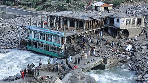 Residents and rescue workers inspect buildings damaged by heavy flooding in the eastern province of Nuristan, Afghanistan, Tuesday, July 21, 2026.