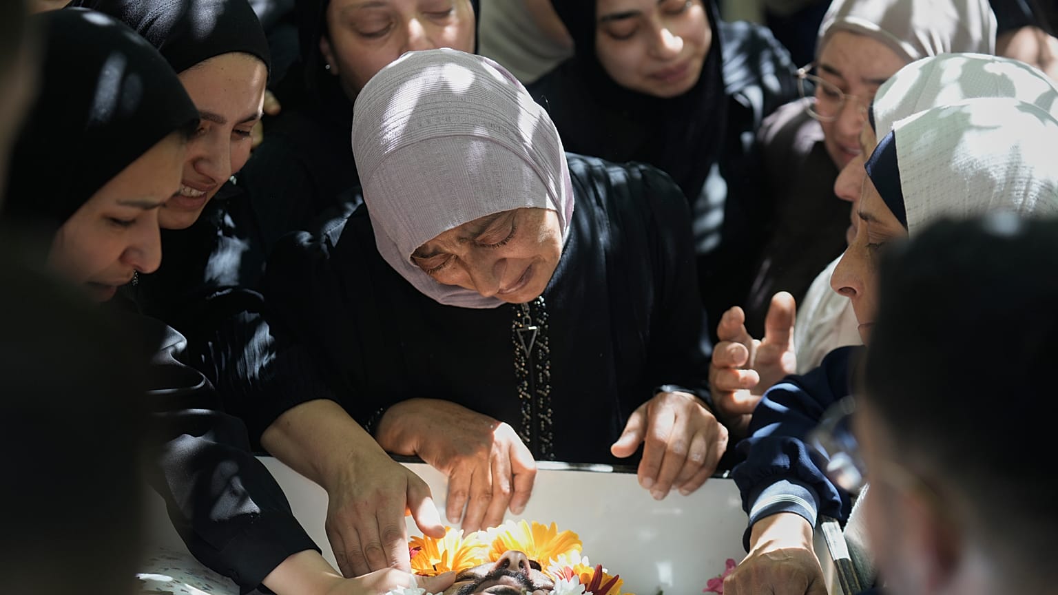 تنعى نساء فلسطينيات جثمان عودة فرحنة، 53 عاماً، الذي قُتل، بحسب السلطات الصحية، بنيران الجيش الإسرائيلي إثر هجوم مستوطن، خلال جنازته في بلدة دير جرير بالضفة الغربية