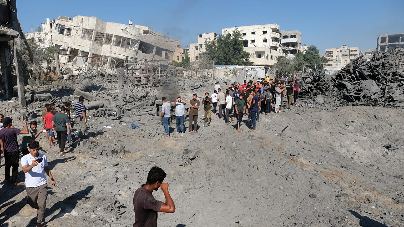 تجمع فلسطينيون حول موقع غارة عسكرية إسرائيلية بطائرة بدون طيار على ورشة حدادة في حي صبرا بمدينة غزة