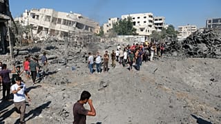 تجمع فلسطينيون حول موقع غارة عسكرية إسرائيلية بطائرة بدون طيار على ورشة حدادة في حي صبرا بمدينة غزة