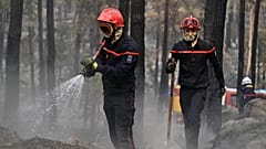 Feuerwehrleute bekämpfen am Dienstag, dem 14. Juli 2026, einen Waldbrand in der Region des Waldes von Fontainebleau südlich von Paris in Frankreich.