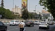 Vehicles drive past a billboard depicting the clenched fist of the late Iranian Supreme Leader Ayatollah Ali Khamenei, in Tehran, Iran, Tuesday, July 21, 2026. 
