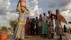 Orta Afrika Cumhuriyeti'nin Birao kentindeki Korsi Mülteci Kampı'nda kadınlar ve çocuklar gün batımında su taşıyor.