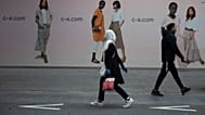 Auf diesem Archivbild vom Montag, 11. Mai 2020, gehen eine Frau und ein Mann auf der Haupteinkaufsstraße in Antwerpen, Belgien, aneinander vorbei.