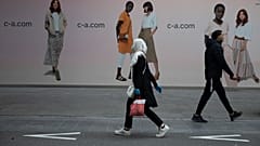 En esta foto de archivo del lunes 11 de mayo de 2020, una mujer y un hombre pasan uno junto al otro en una calle comercial principal de Amberes, Bélgica.