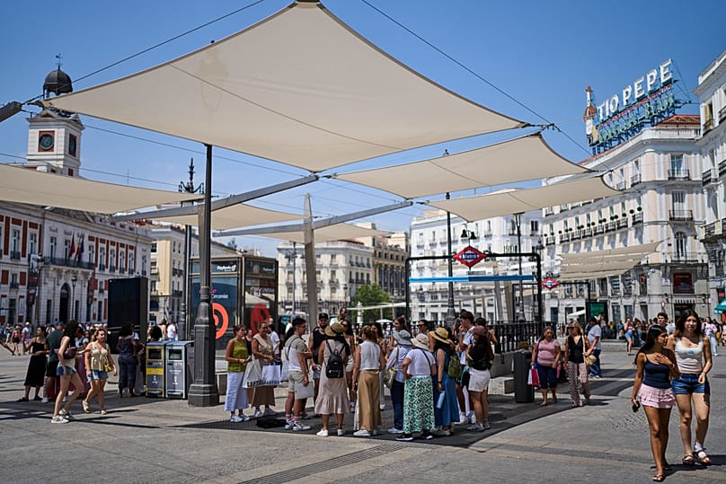 Τουρίστες καταφεύγουν στη σκιά κατά τη διάρκεια καύσωνα στο κέντρο της Μαδρίτης, Ισπανία, την Πέμπτη 9 Ιουλίου 2026. (Φωτογραφία AP/Bernat Armangue)