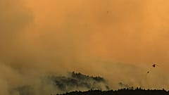 Un helicóptero contra incendios arroja agua sobre las llamas mientras un incendio forestal avanza cerca de Condemios de Arriba, Guadalajara, el 22 de julio de 2026.
