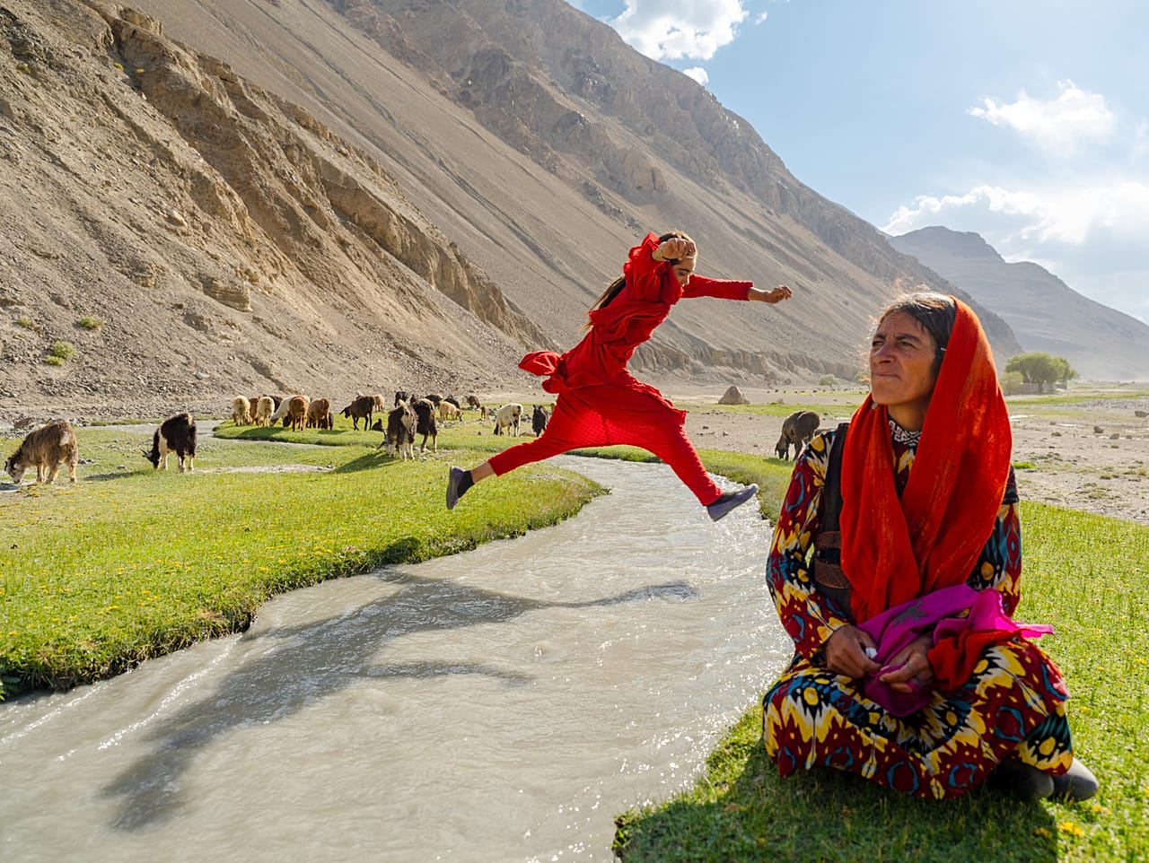 Rapariga adolescente a saltar sobre um rio em Wakhan, do projeto Afghanistan de Daniel Malikyar 