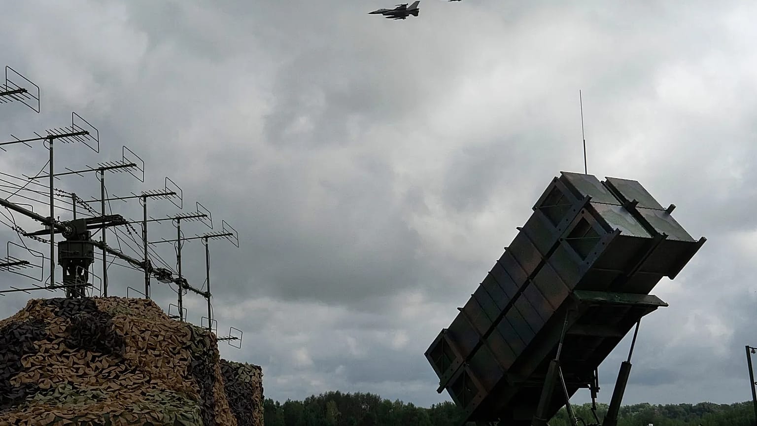 Cazas F-16 de la Fuerza Aérea de Ucrania vuelan sobre un sistema de defensa antiaérea y antimisiles Patriot en un lugar no revelado de Ucrania, el cuatro de agosto de 2024.