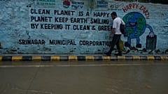 Un hombre camina junto al borde de una calle inundada tras fuertes lluvias en Srinagar, Cachemira bajo control indio, lunes 20 de julio de 2026.