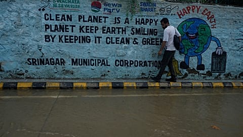 A man walks along the edge of a flooded street after heavy rainfall in Srinagar, Indian controlled Kashmir, Monday, July 20, 2026.