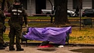Agentes de la Policía custodian un cadáver sobre un banco del parque bajo la lluvia en Santiago de Chile, el lunes 20 de julio de 2026.