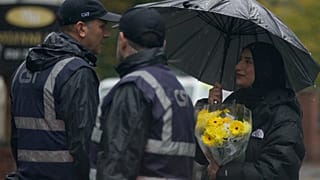 A woman carrying flowers attends a vigil for the victims of the attack at Heaton Park Hebrew Congregation synagogue in Manchester, England, Friday, 3 October 2025.