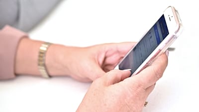 Osoba korzystająca z telefonu komórkowego.