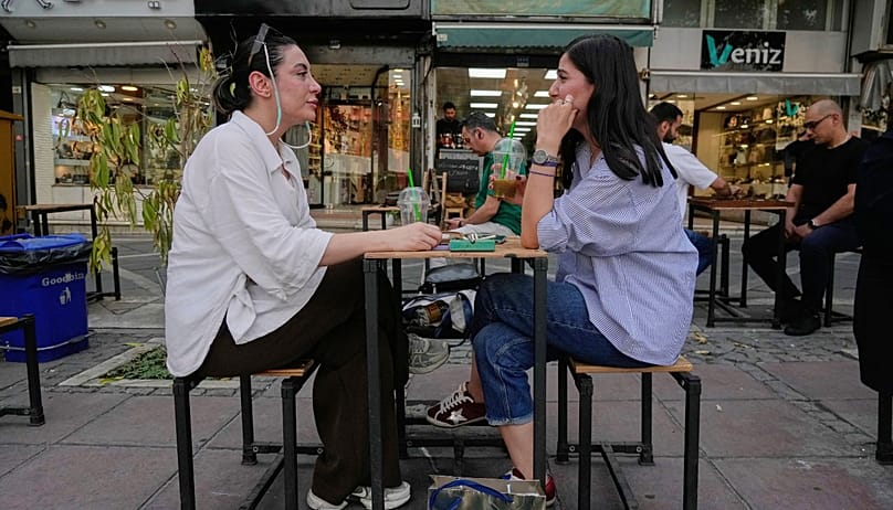 Women sit in the outdoor dining area of a cafe in downtown Tehran, Wednesday, July 22, 2026. (AP Photo/Vahid Salemi)
