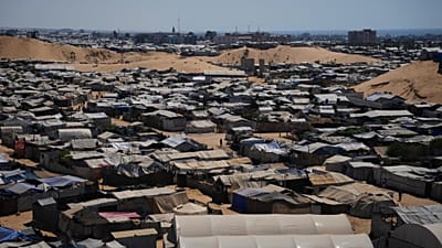 Photo d'archive : des Palestiniens déplacés marchent entre des tentes dans un camp de fortune à Khan Younis, sud de la bande de Gaza, 1er juillet 2026