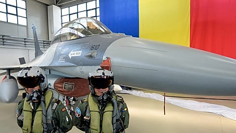 Piloti romeni accanto a un caccia F16 dell'Aeronautica militare romena, parcheggiato in un hangar della base aerea 86 a Borcea, nel sud della Romania, venerdì 7 ottobre 2016.