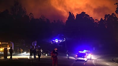 Na zdjęciu archiwalnym radiowozy blokują teren, gdy służby ratunkowe reagują na pożar lasu w As Neves, Pontevedra, w galicyjskiej Hiszpanii, 16 X 2017.