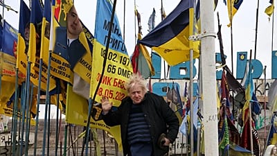 El ex primer ministro británico Boris Johnson, ante el letrero de entrada a Orikhiv, rodeado de banderas ucranianas y militares, Zaporiyia, el 26 de febrero de 2026.