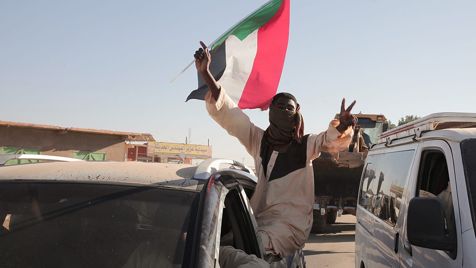 رجل سوداني يلوح بعلم السودان بعد ورود أنباء عن دخول الجيش السوداني مدينة ود مدني وسط البلاد وطرد قوات الدعم السريع (RSF) المنافسة له، في مروي، السودان، السبت 11 يناير 2025. (ص