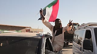 رجل سوداني يلوح بعلم السودان بعد ورود أنباء عن دخول الجيش السوداني مدينة ود مدني وسط البلاد وطرد قوات الدعم السريع (RSF) المنافسة له، في مروي، السودان، السبت 11 يناير 2025. (ص