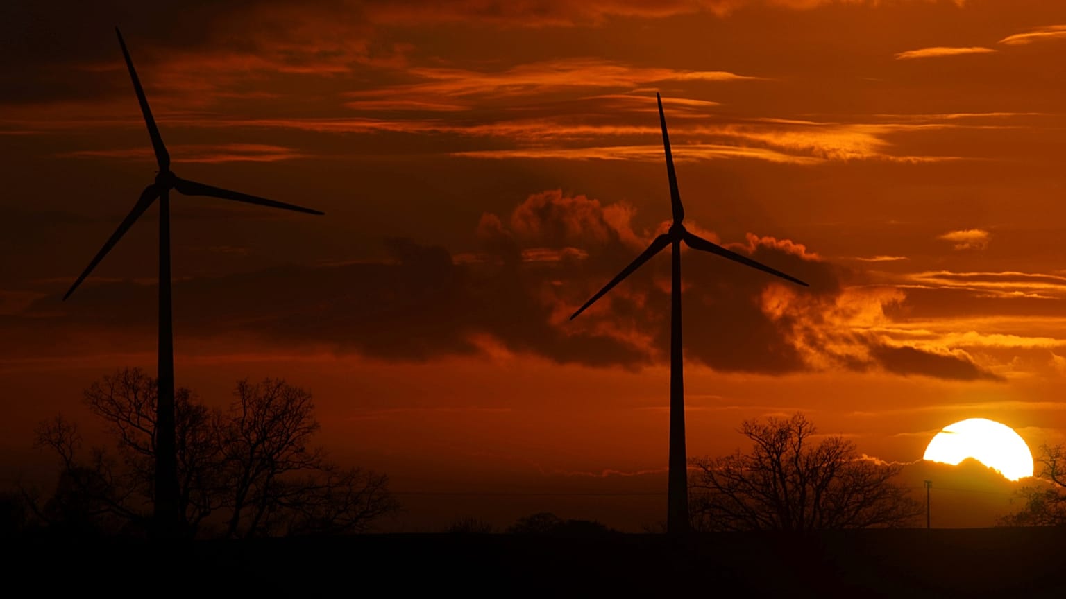 Die Sonne geht hinter Windrädern bei Pokrent in Norddeutschland unter, aufgenommen am Freitag, dem 17. November 2017.